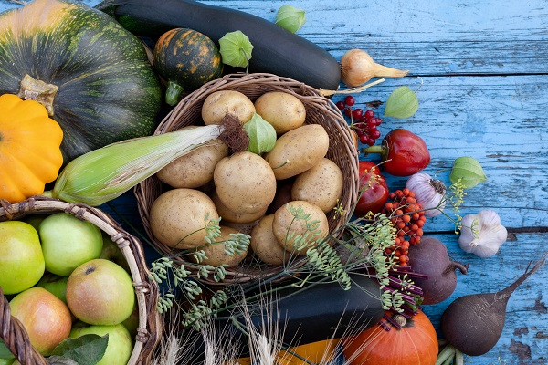 Diverse groenten en fruit in een mand op een houten tafel